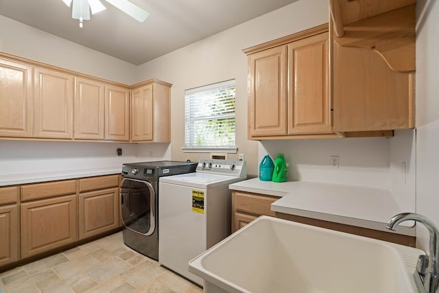 clothes washing area with sink, washer and clothes dryer, cabinets, and ceiling fan