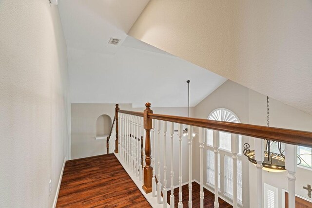 hallway featuring lofted ceiling and dark wood-type flooring