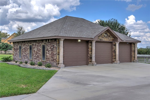 view of side of property featuring a garage and a lawn