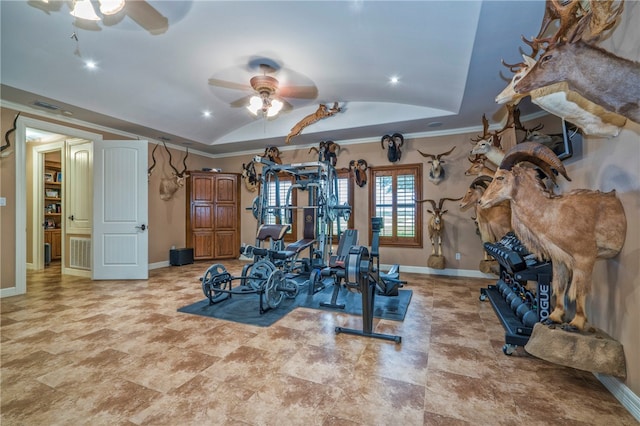 exercise area featuring ceiling fan, crown molding, and a tray ceiling