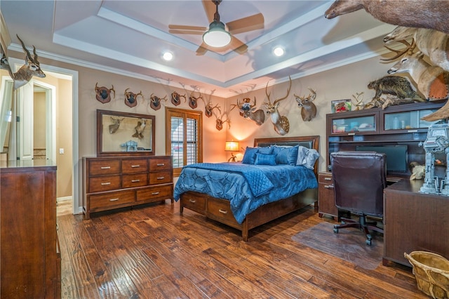 bedroom featuring dark hardwood / wood-style flooring, ornamental molding, ceiling fan, and a raised ceiling