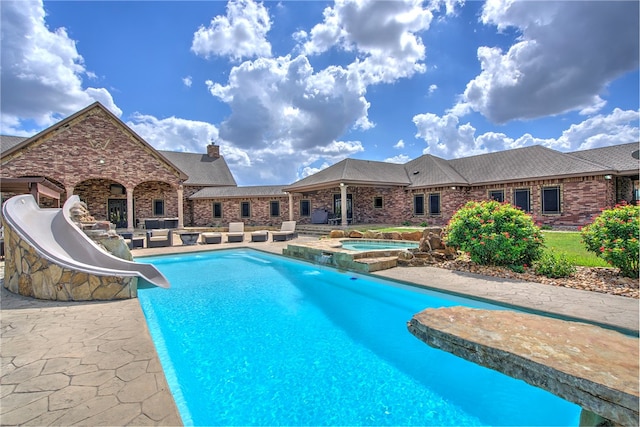 view of swimming pool with an in ground hot tub, a patio, and a water slide