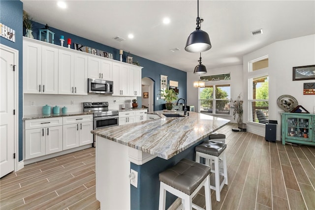 177 Glenvalley Cir, Bandera, TX 78003 - kitchen featuring a sink, appliances with stainless steel finishes, recessed lighting, arched walkways, and light wood-style floors
