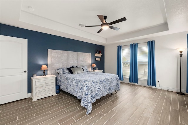 177 Glenvalley Cir, Bandera, TX 78003 - bedroom with a raised ceiling, baseboards, and wood finished floors