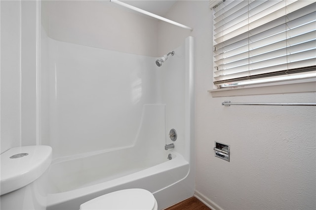 bathroom with shower / washtub combination and toilet