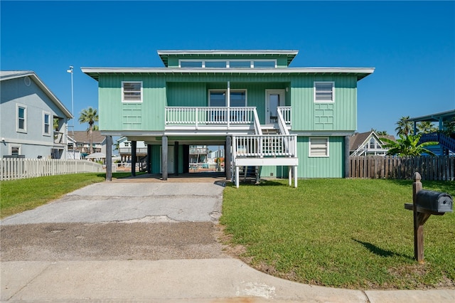 coastal home with a carport, a front yard, and covered porch