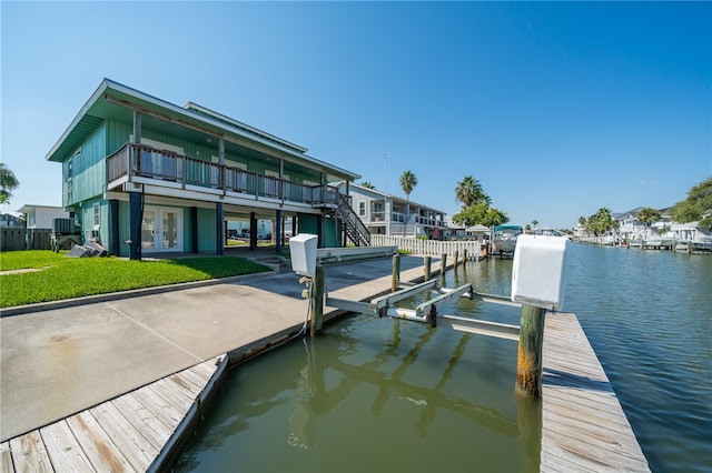 dock area with a water view and a lawn