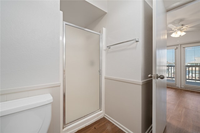 bathroom featuring toilet, hardwood / wood-style flooring, ceiling fan, and a shower with shower door