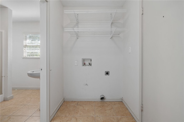 washroom featuring hookup for a washing machine, light tile patterned floors, and hookup for an electric dryer