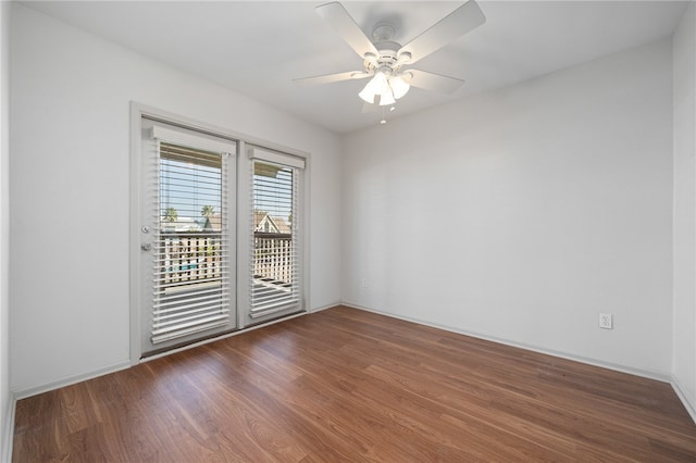 spare room with dark wood-type flooring and ceiling fan