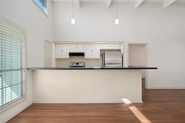 kitchen featuring white cabinetry, kitchen peninsula, hanging light fixtures, and stainless steel fridge