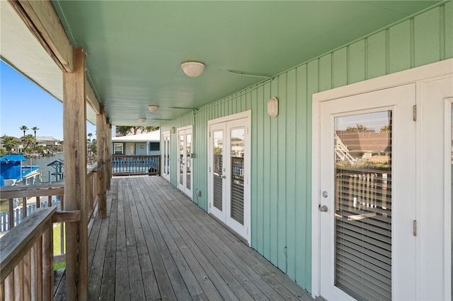 wooden terrace featuring a water view and ceiling fan