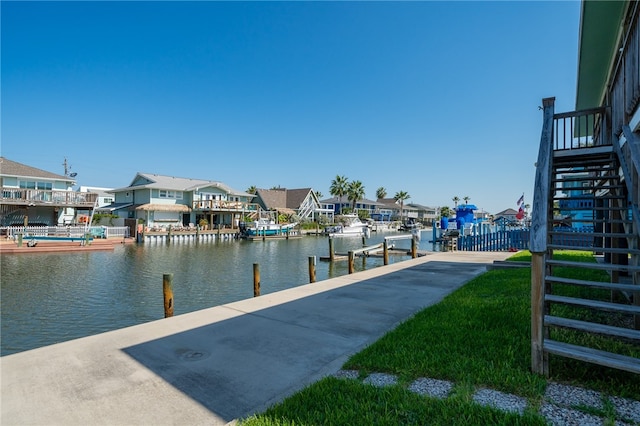 view of dock with a water view and a lawn