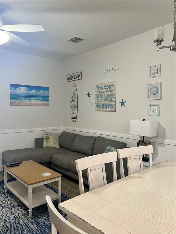 living room featuring ceiling fan with notable chandelier