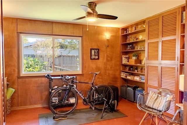 misc room with ceiling fan, built in features, and wooden walls