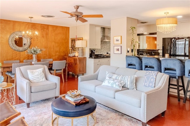 living room with ceiling fan with notable chandelier