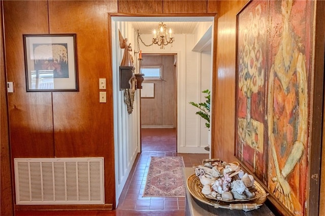 interior space featuring a notable chandelier and wooden walls