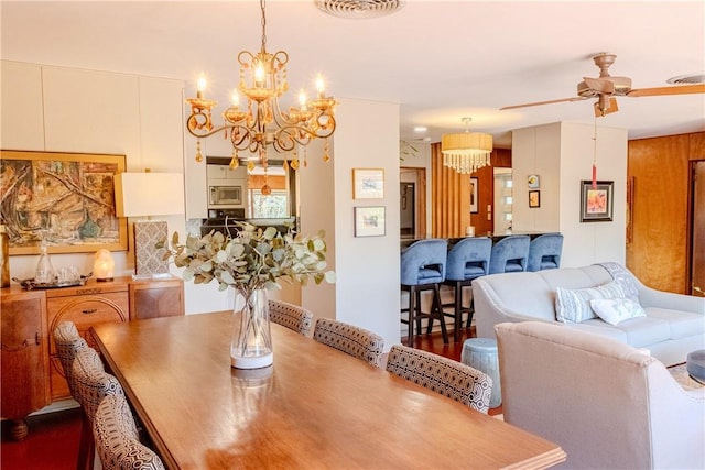 dining area with ceiling fan with notable chandelier