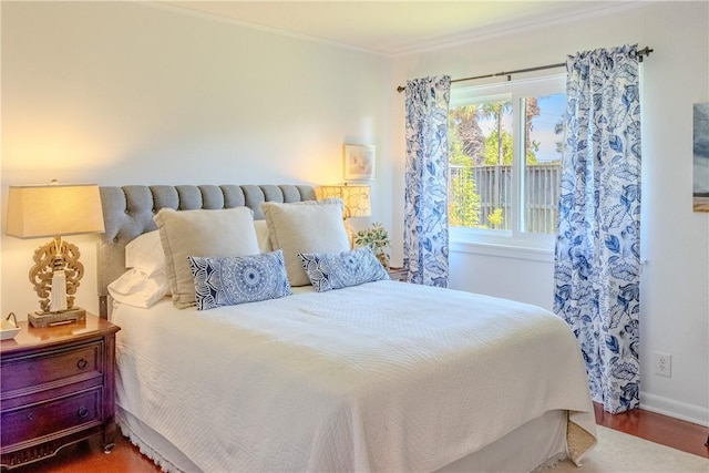 bedroom with multiple windows, crown molding, and hardwood / wood-style flooring