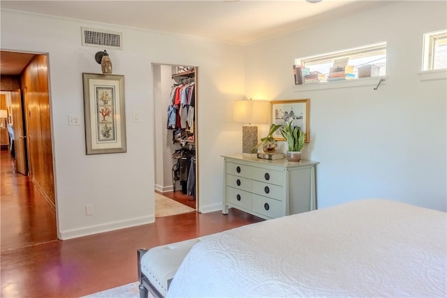 bedroom featuring ornamental molding, a spacious closet, and a closet