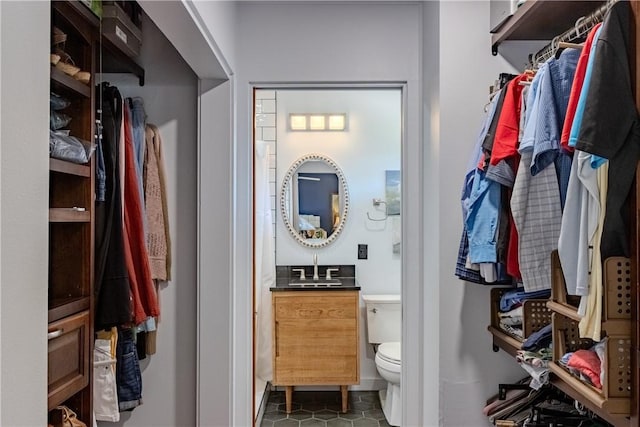 walk in closet featuring dark tile patterned floors