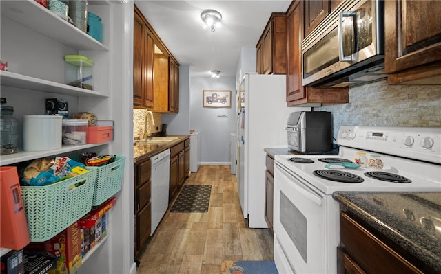 kitchen with white appliances, sink, light wood-type flooring, and tasteful backsplash