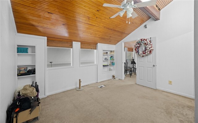 interior space featuring built in shelves, lofted ceiling, light carpet, and ceiling fan