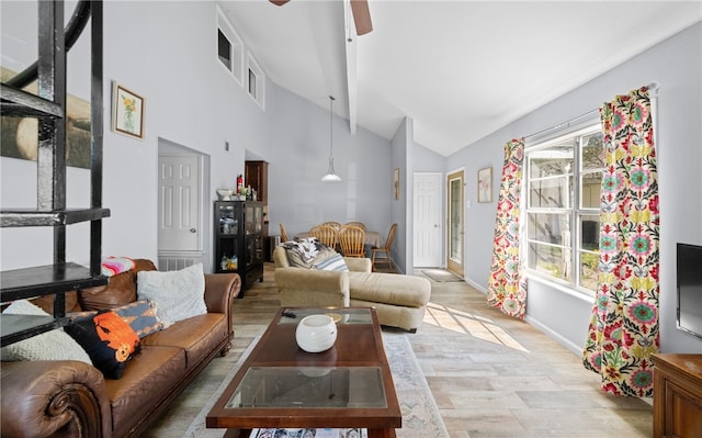 living room featuring high vaulted ceiling, light hardwood / wood-style floors, and ceiling fan