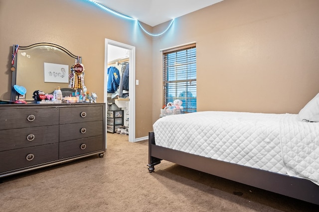 carpeted bedroom with a closet and a walk in closet