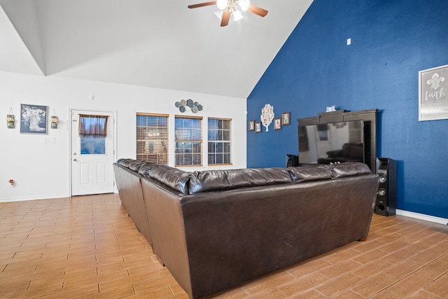 living room with ceiling fan, light wood-type flooring, and high vaulted ceiling