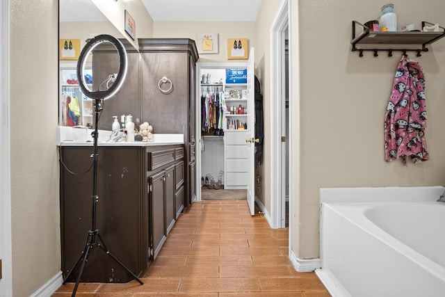 bathroom featuring vanity, wood-type flooring, and a tub