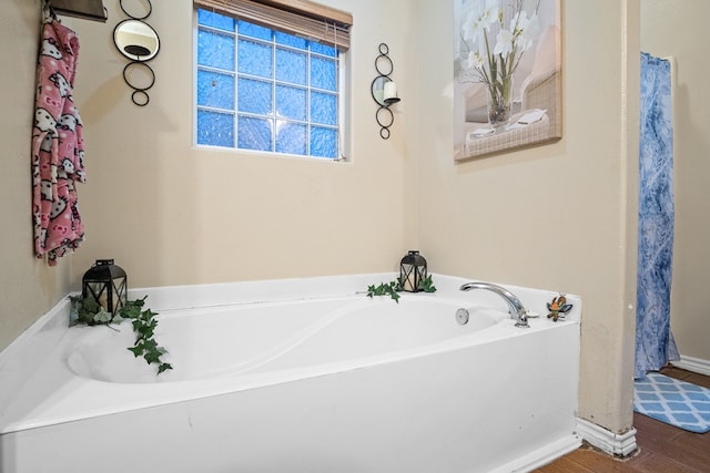 bathroom featuring wood-type flooring and a tub to relax in