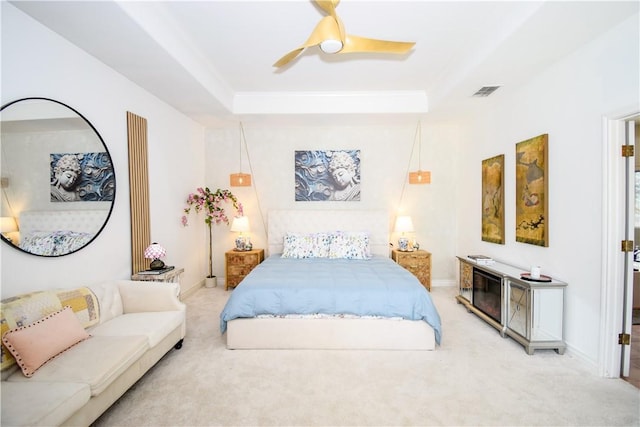 15854 El Soccorro, Corpus Christi, TX 78418 - bedroom featuring light carpet, a tray ceiling, and a ceiling fan