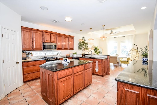 15854 El Soccorro, Corpus Christi, TX 78418 - kitchen with stainless steel appliances, a peninsula, a kitchen island, light tile patterned floors, and recessed lighting