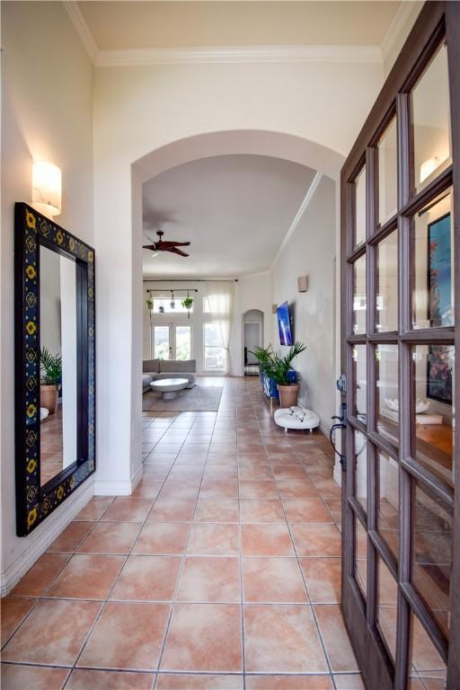 15854 El Soccorro, Corpus Christi, TX 78418 - corridor featuring arched walkways, crown molding, and light tile patterned floors