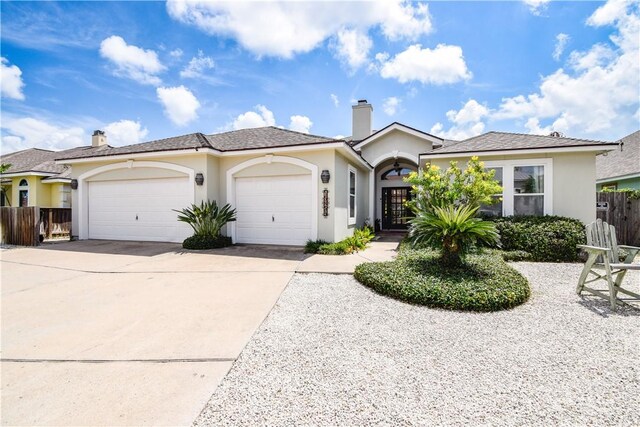 15854 El Soccorro, Corpus Christi, TX 78418 - ranch-style house with a garage, concrete driveway, a chimney, and stucco siding