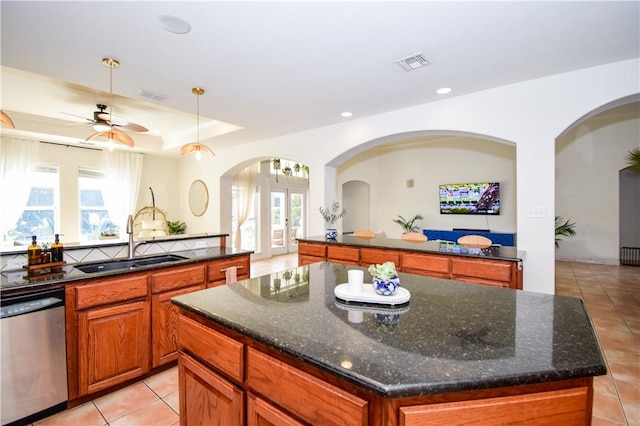 15854 El Soccorro, Corpus Christi, TX 78418 - kitchen featuring dishwasher, light tile patterned floors, arched walkways, a ceiling fan, and brown cabinetry