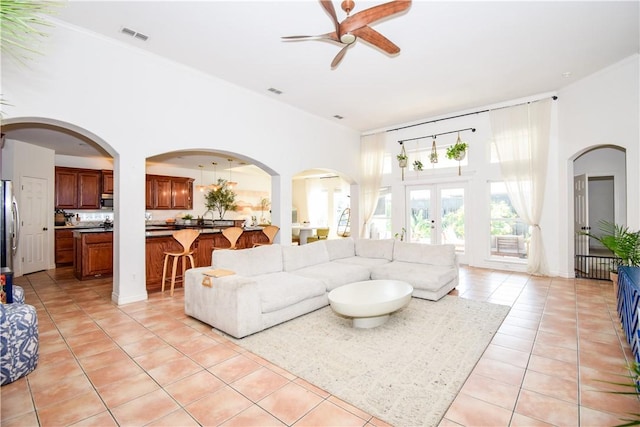 15854 El Soccorro, Corpus Christi, TX 78418 - living area featuring light tile patterned flooring, ceiling fan, a high ceiling, and arched walkways
