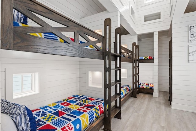 bedroom featuring wood walls and light wood-style flooring