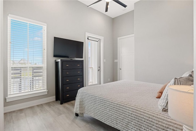 bedroom with light wood-style floors, ceiling fan, baseboards, and multiple windows