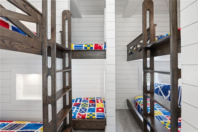 bedroom featuring wood walls and wood finished floors