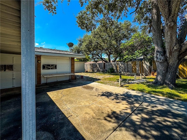 view of yard with a garage and a patio area