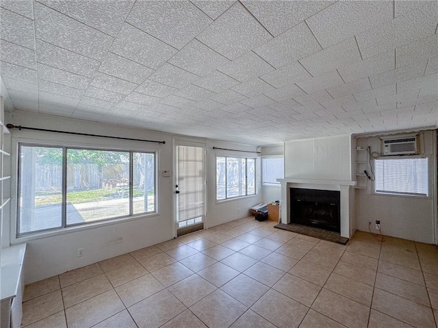 unfurnished living room with light tile patterned floors and a wall mounted air conditioner