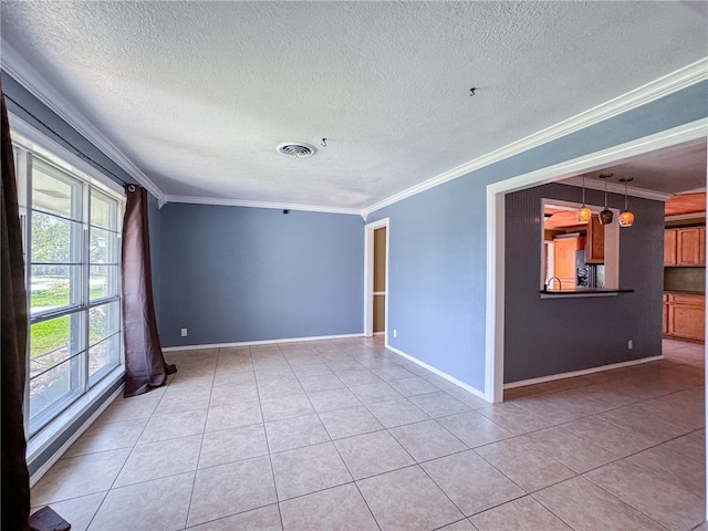 tiled spare room featuring a textured ceiling and ornamental molding