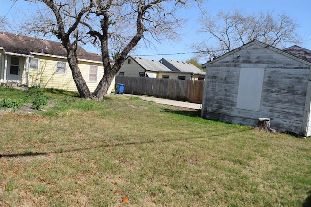 view of yard featuring an outbuilding, a storage unit, and fence