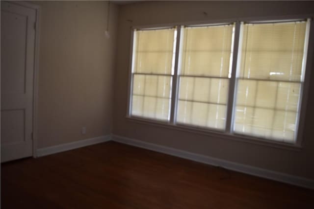 empty room featuring baseboards and wood finished floors