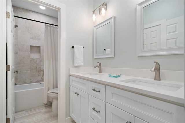 full bathroom with shower / tub combo, vanity, and toilet