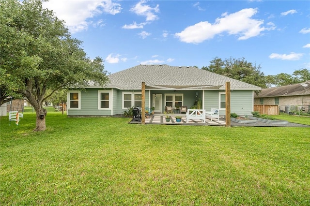 back of property with ceiling fan, a patio area, and a lawn