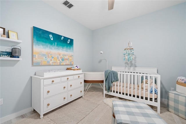 bedroom featuring ceiling fan and a crib