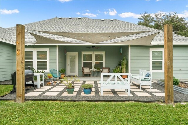 back of property with a lawn, ceiling fan, and a patio